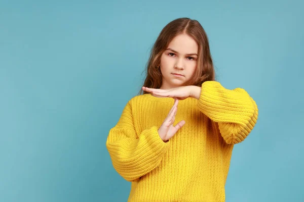 タイムアウトを示す小さな愛らしい少女の肖像画 子供は 黄色のカジュアルなスタイルのセーターを着て 印象的な表現で休憩を求めている 青い背景に隔離された屋内スタジオショット — ストック写真