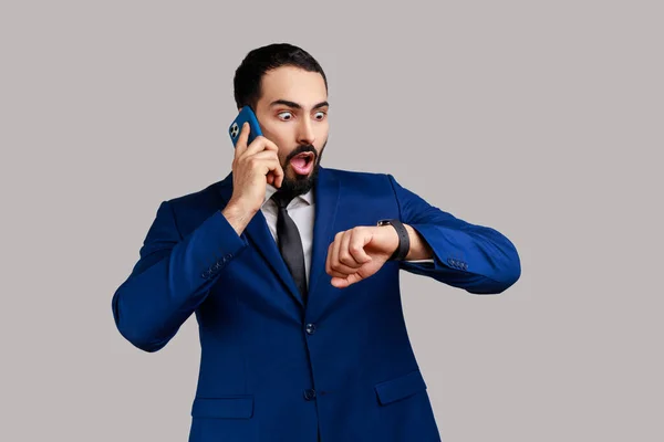 Portret Przystojnego Brodatego Mężczyzny Rozmawiającego Przez Telefon Patrzącego Zegarek Spóźniającego — Zdjęcie stockowe