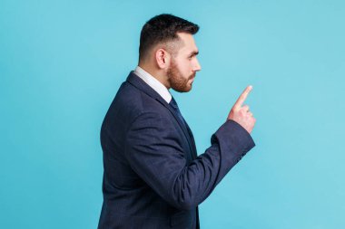 Söylemiştim sana! Resmi stil takım elbise giyen ciddi bir adamın işaret parmağıyla dikilip uyarı işareti yapan portresi. Dikkatli olun. Mavi arka planda kapalı stüdyo çekimi.