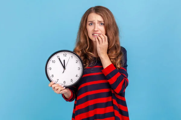 Verwirrte Frau Gestreiftem Lässigem Pullover Wanduhr Der Hand Beißende Nägel — Stockfoto