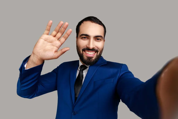 Pozytywny Przyjazny Brodaty Biznesmen Robi Selfie Lub Streaming Macha Ręką — Zdjęcie stockowe