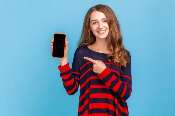 Positive Woman Wearing Striped Casual Style Sweater Pointing Smart Phone — Fotografia de Stock