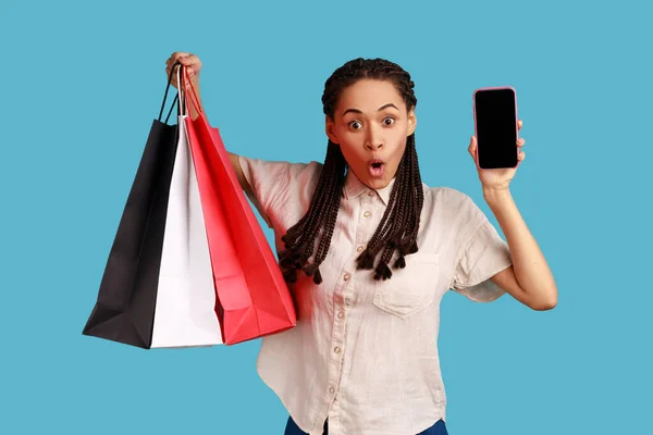 Portrait Shocked Woman Black Dreadlocks Holding Shopping Bags Showing Smart — стоковое фото