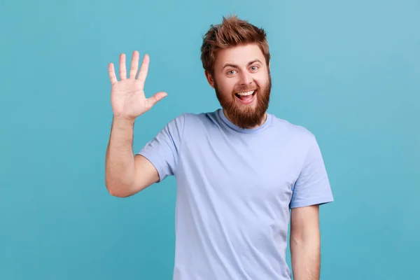 Portrait Positive Bearded Man Greeting You Rising Hand Waving Saying — Stock fotografie