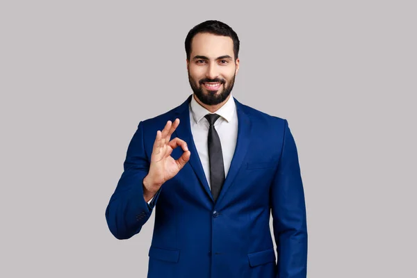 Portrait Delighted Bearded Man Standing Looking Camera Showing Sign Gesture — Stockfoto
