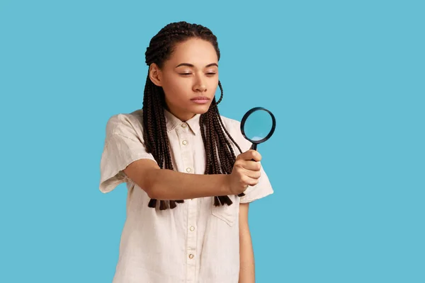 Attractive Curious Woman Black Dreadlocks Looking Away Magnifying Glass Spying — Stok fotoğraf