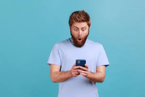 Şaşırmış Genç Sakallı Adamın Portresi Akıllı Telefon Kullanarak Hayret Dolu — Stok fotoğraf