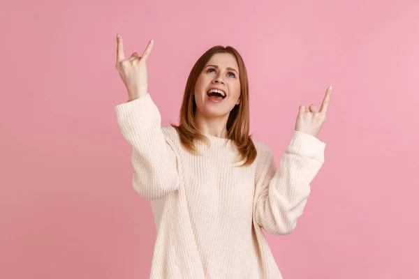 여자가 손가락으로 로큰롤 동작을 콘서트에서 스웨터를 즐겁게 스튜디오 배경에서 고립되어 — 스톡 사진
