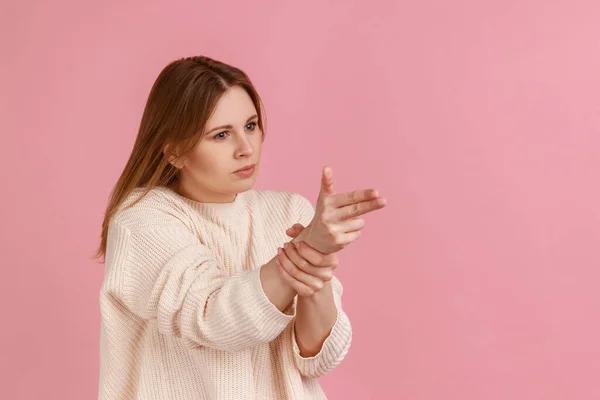 스웨터를 권총으로 겨누며 쏘겠다고 위협하는 여성의 스튜디오 배경에서 고립되어 — 스톡 사진