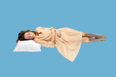 Uyuyan güzel havada süzülüyor. Sarı elbiseli rahat bir kız yastığın üzerinde rahatça uzanıyor, gözlerini kapalı tutuyor, rüyalar izliyor. Mavi arkaplanda kapalı alanda tam uzunlukta stüdyo çekimi