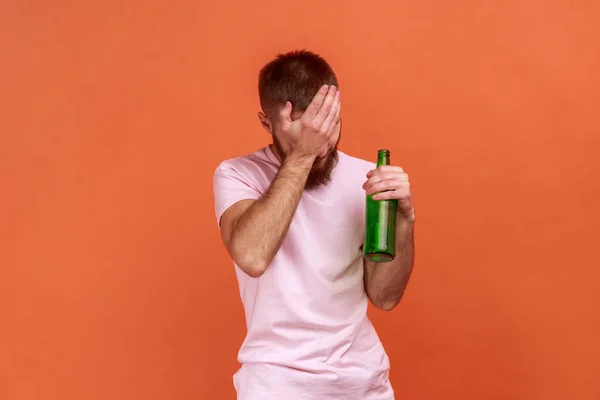 Portret Smutnego Brodatego Mężczyzny Stojącego Butelką Piwa Pijanego Zakrywającego Twarz — Zdjęcie stockowe