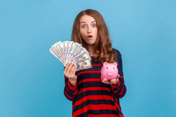 Shocked Woman Wearing Striped Casual Style Sweater Holding Piggy Bank — Stock Photo, Image