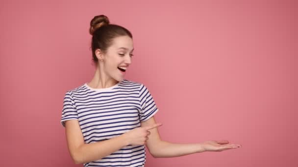 Retrato Mujer Extremadamente Feliz Con Peinado Bollo Apuntando Con Dedo — Vídeos de Stock