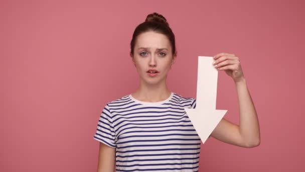 Upset Woman Bun Hairstyle Holding White Arrow Pointing Looking Camera — Stock Video