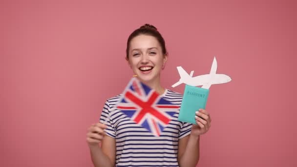 Glückliche Schöne Frau Mit Haarschopf Papierflugzeug Pass Und Britischer Flagge — Stockvideo