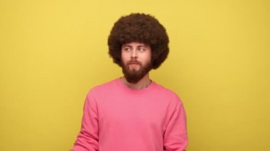 Afro saçlı sakallı bir adam Amerika Birleşik Devletleri bayrak vatanseverliği, bağımsızlık, ulusal bayramı kutlamak, pembe eşofman altı giyiyor. Sarı arka planda kapalı stüdyo çekimleri.