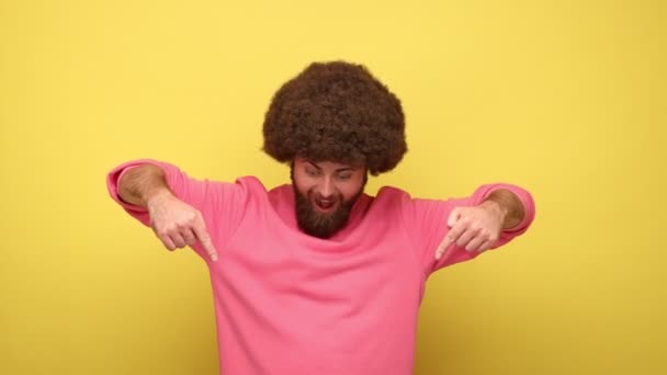 Homem Barbudo Animado Com Penteado Afro Apontando Para Baixo Com — Vídeo de Stock