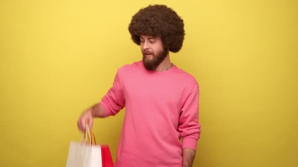 Bärtiger Hipstermann Mit Afro Frisur Der Auf Die Verpackung Zeigt — Stockvideo