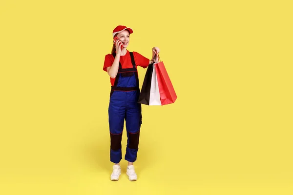 Elinde Alışveriş Poşetleri Olan Gülümseyen Kurye Kadın Portresi Müşteriyle Telefonda — Stok fotoğraf