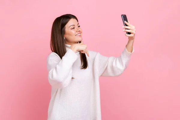 Pozytywne Brunetka Kobieta Robi Selfie Lub Livestream Wskazując Palcem Dół — Zdjęcie stockowe