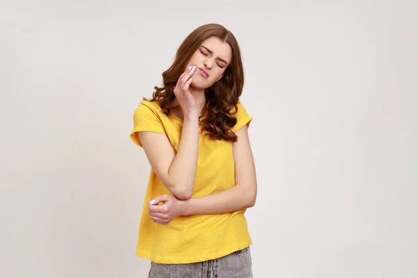 Sfrustrowana Falowana Nastolatka Żółtej Luźnej Koszulce Dotykająca Policzka Kołysząca Się — Zdjęcie stockowe