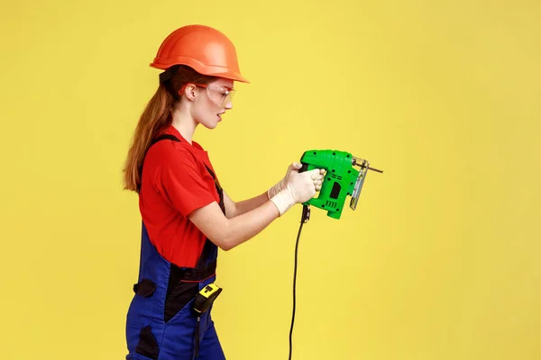 활톱을 사용하여 일하는건 축가의 작업복을 헬멧을 확신을 표현하는 스튜디오 가노란 — 스톡 사진