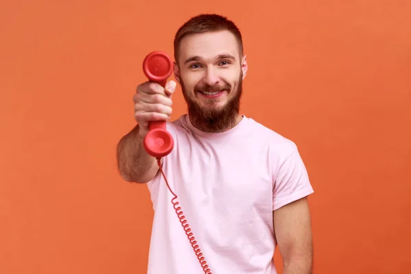 Retrato Hombre Barbudo Feliz Sonriente Sosteniendo Mostrando Auricular Del Teléfono —  Fotos de Stock