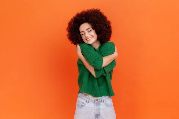 Woman Afro Hairstyle Wearing Green Casual Sweater Hugging Herself Smiling — Stock Fotó