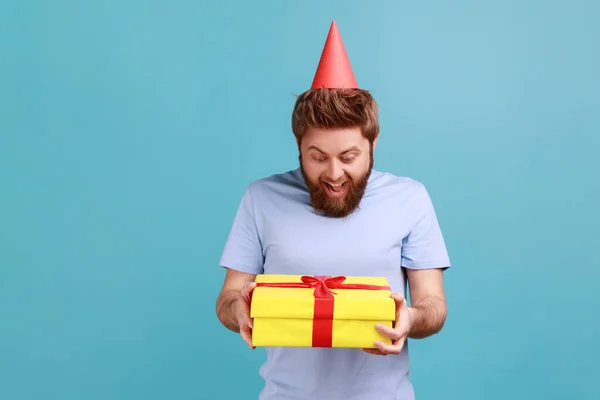 Portrait Excited Surprised Bearded Man Party Cone Holding Yellow Wrapped — Stock Fotó