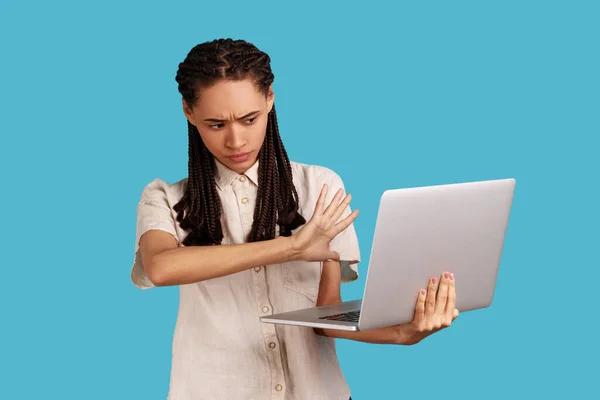 黑发女子的画像 对手提电脑显示停止姿势 内容被禁 厌恶地看着 穿着白衬衫 室内拍摄被蓝色背景隔离 — 图库照片