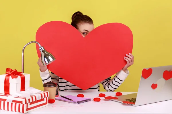 Portrait Shy Woman Sitting Workplace Holding Peeping Big Red Heart — 图库照片