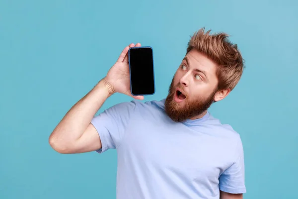 Portrait Bearded Man Standing Holding Mobile Phone Looking Surprise Gadget — Stok fotoğraf