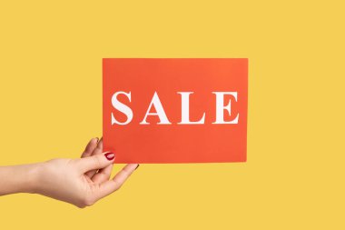 Profil yan görüntüsü, elinde kırmızı kart, mega alışveriş, kara cuma indirimleri olan bir kadının resmi. Sarı arka planda kapalı stüdyo çekimleri.