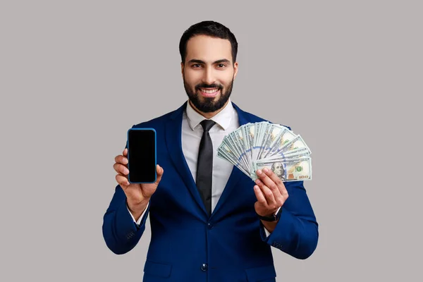 Mosolygó Elégedett Szakállas Üzletember Dollárbankjegyekkel Mobiltelefonnal Üres Kijelzővel Hivatalos Öltönyben — Stock Fotó