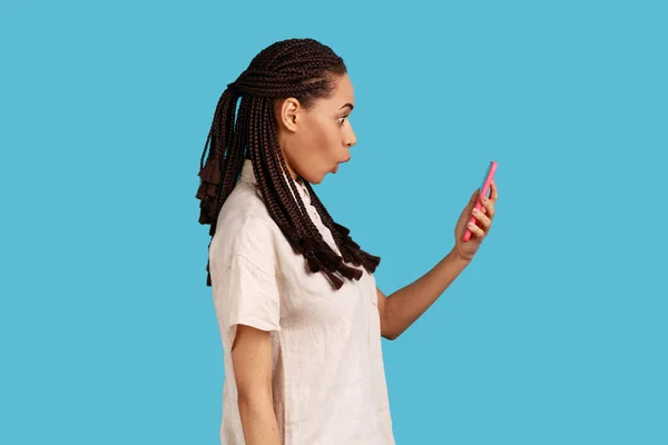 Widok Boku Zaskoczonej Kobiety Czarnymi Dredami Gapi Się Ekran Smartfona — Zdjęcie stockowe