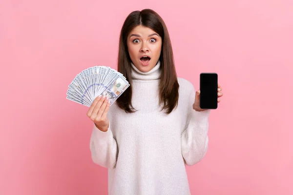Šokovaná Žena Drží Velkou Sumu Dolarů Ukazuje Chytrý Telefon Prázdnou — Stock fotografie