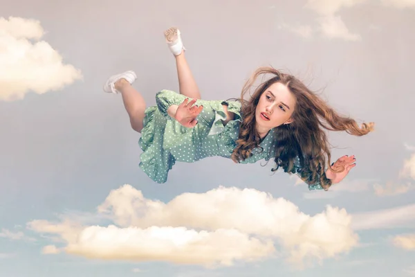 空中に浮かぶ美しい少女が落下し 髪が風から舞い上がるのを混乱させ 空で夢のような穏やかな表情でホバリング飛行モデル 曇り空のコラージュ作品 — ストック写真