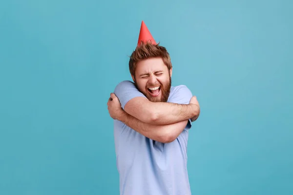 Retrato Hombre Barbudo Extremadamente Feliz Usando Cono Fiesta Abrazándose Con — Foto de Stock