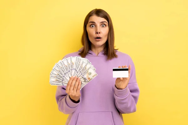 머리에 지폐와 카드의 은행을 보라색 후드를 충격받은 여성의 스튜디오 가노란 — 스톡 사진