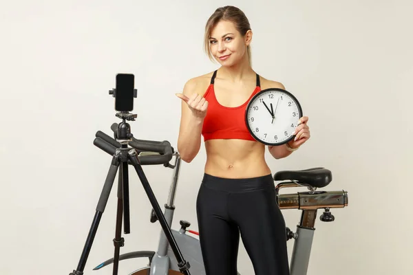 Athletic Woman Standing Wall Clock Hands Pointing Phone Tripod Tutorial — Stock Photo, Image