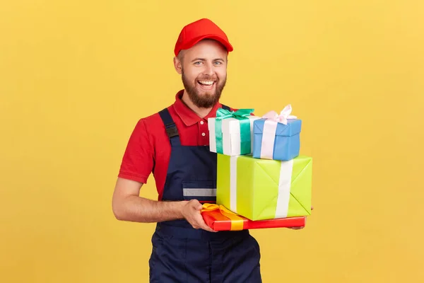 Portrait Positive Happy Delivery Man Wearing Uniform Cap Holding Many — Zdjęcie stockowe