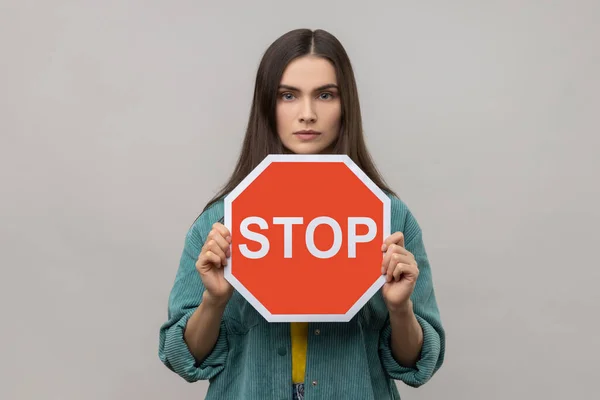 Serious Woman Dark Hair Holding Red Stop Sign Looking Camera — Stockfoto