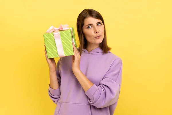 Portrait Curious Dark Haired Woman Holding Shaking Green Wrapped Present — Stok fotoğraf