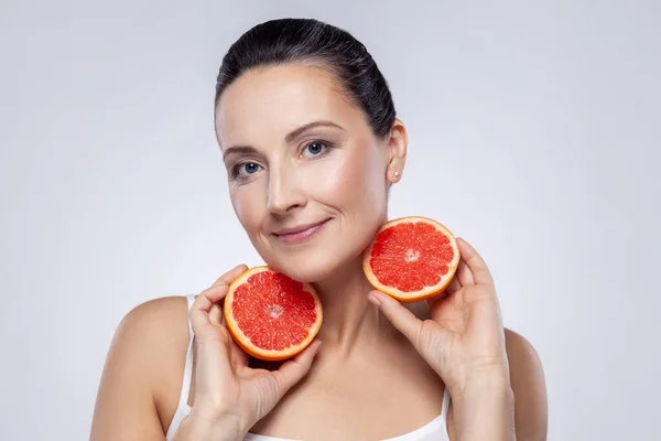 Closeup Portrait Middle Aged Woman Showing Sliced Grapefruit Looking Camera — Fotografia de Stock