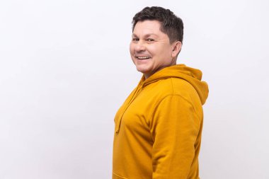 Yakışıklı, orta yaşlı, siyah saçlı, kameraya bakan, gülümseyen, kentsel kapüşonlu kapüşonlu bir adam. Beyaz arka planda izole edilmiş kapalı stüdyo görüntüleri.