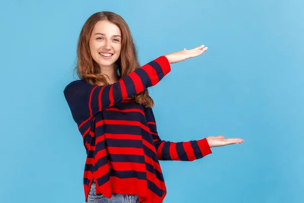 Optimistic Woman Wearing Striped Casual Style Sweater Presenting Copy Space — Foto de Stock
