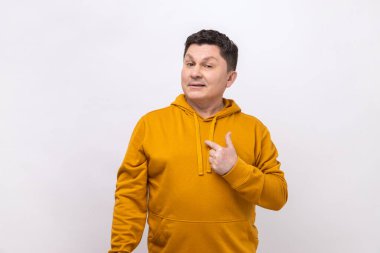 Proud handsome man pointing fingers on himself and looking at camera with pride, extremely confident, wearing urban style hoodie. Indoor studio shot isolated on white background.