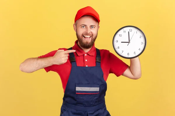 Portrait Delighted Man Worker Standing Pointing Big Wall Clock His — Fotografia de Stock
