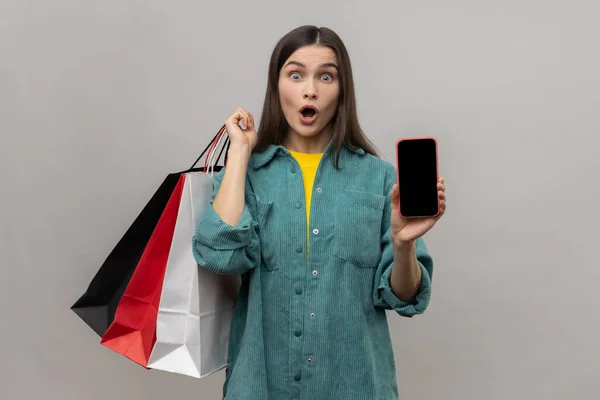 Amazed Woman Standing Astonished Look Showing Shopping Bags Smart Phone — Stok fotoğraf