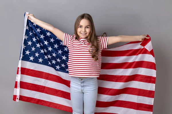 Portrait Winsome Little Girl Wearing Striped Shirt Holding Huge American — Zdjęcie stockowe